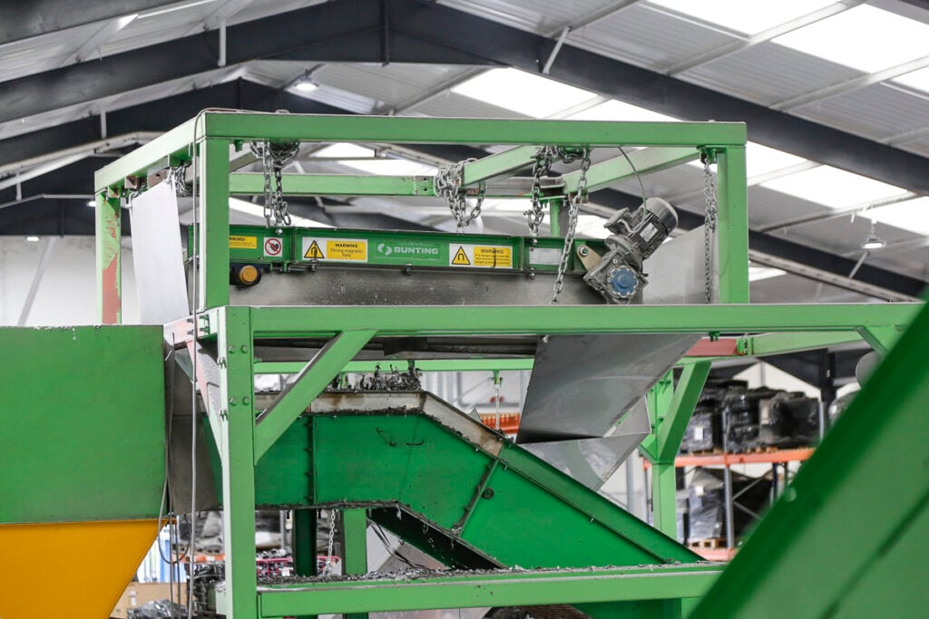 Overband magnet installed above a conveyor in an e-waste recycling plant
