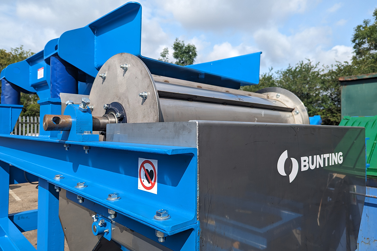 Permanent drum magnet and vibratory feeder mounted on a blue frame