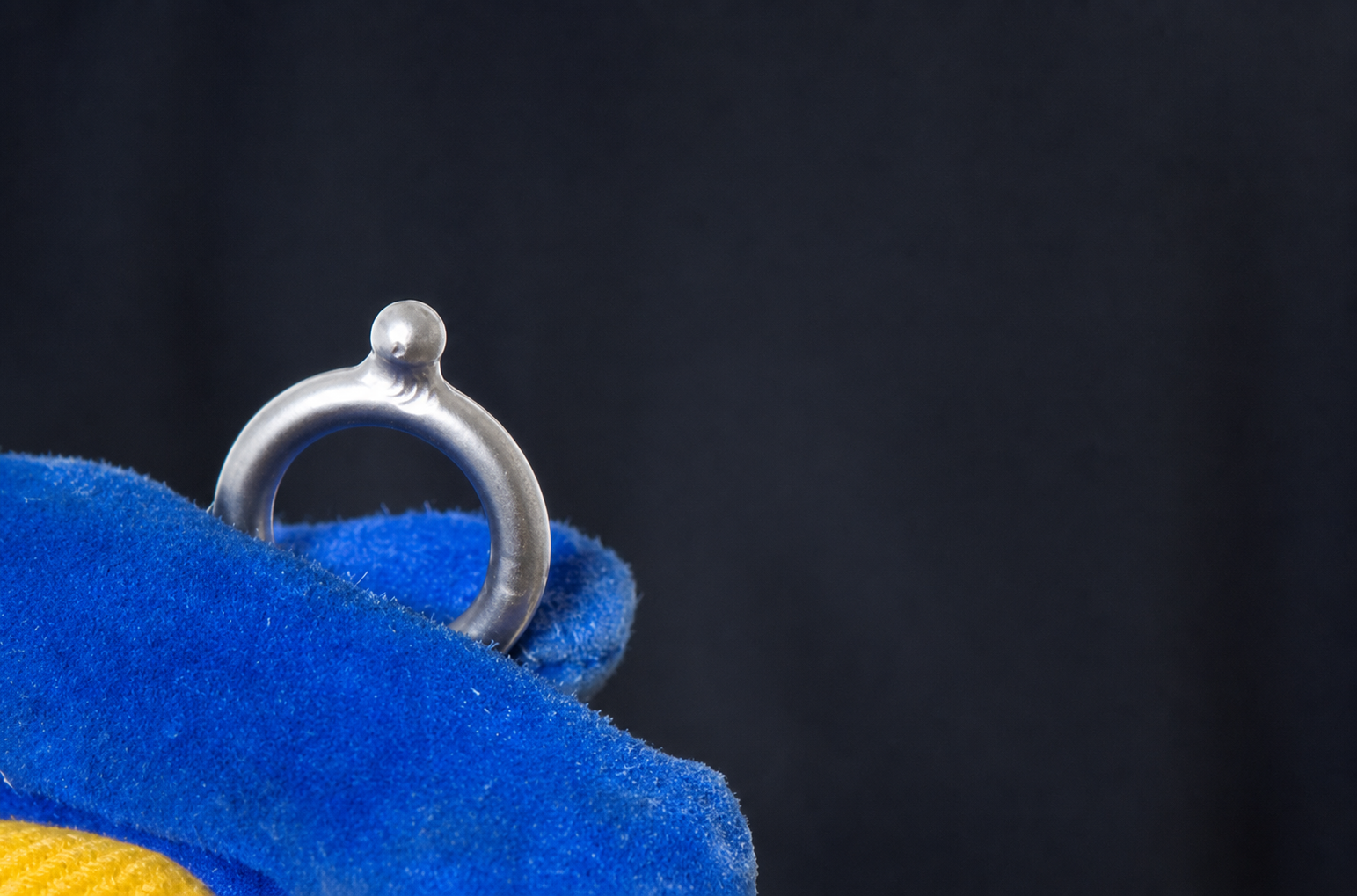 Steel magnetic pull-test piece held in a protective glove